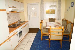 a kitchen with a table and chairs and a kitchen with a sink at Ferienwohnungen Tietgen in Katharinenhof