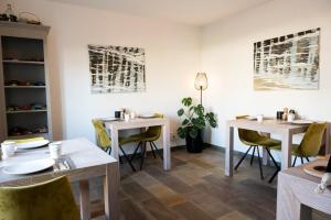 a dining room with two tables and chairs at B&B Witvliet, kamers en studio met heerlijk ontbijt ! in Zoutelande