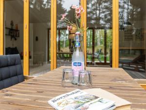 a bottle of water sitting on a wooden table with glasses at Holiday Home Simona - 800m from the sea in Bornholm in Vester Sømarken