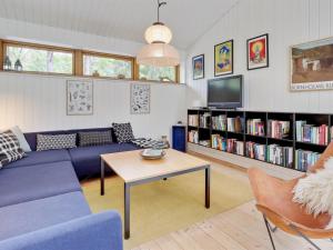 a living room with a couch and a table and a tv at Holiday Home Nuka - 800m from the sea in Bornholm by Interhome in Vester Sømarken