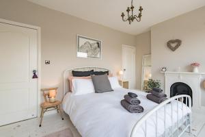 a bedroom with a white bed with towels on it at The House in Deal in Deal