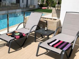 two chairs and a table with a bottle of wine at Beach Avenue Residence in Arenales del Sol