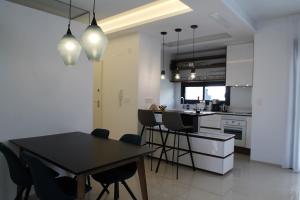 a kitchen and dining room with a table and chairs at Beach Avenue Residence in Arenales del Sol