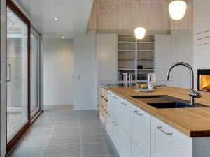een keuken met witte kasten en een wastafel bij Holiday Home Vanta - 10m from the sea in Sealand by Interhome in Gilleleje