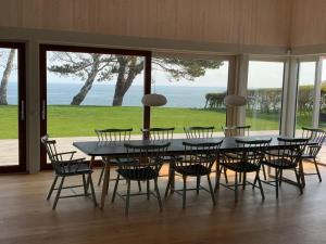 een eetkamer met een tafel en stoelen en de oceaan bij Holiday Home Vanta - 10m from the sea in Sealand by Interhome in Gilleleje