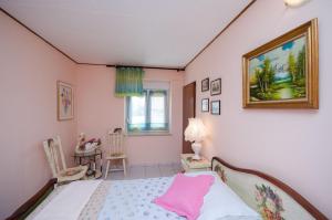 een slaapkamer met een bed en een foto aan de muur bij House Rita in Rakalj