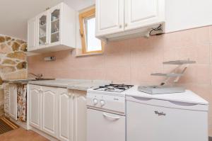 a kitchen with white cabinets and a stove top oven at House Lucica in Splitska
