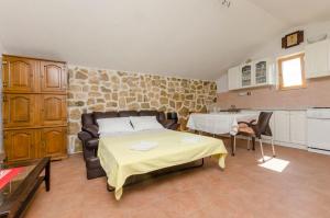 a bedroom with a bed and a table and a kitchen at House Lucica in Splitska