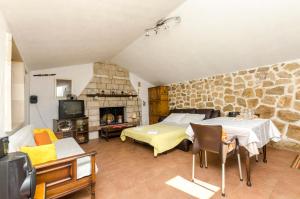 a bedroom with a bed and a stone wall at House Lucica in Splitska