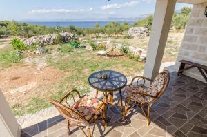 a table and chairs on a porch with a view of the ocean at House Lucica in Splitska
