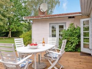 einen Tisch und Stühle auf einer Terrasse mit einem Haus in der Unterkunft Holiday Home Åsemarie - 600m from the sea in Sealand by Interhome in Dronningmølle