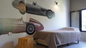 a bedroom with a bed with a car on the wall at Eos Sporthaus in Río Ceballos