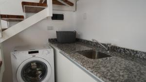 a kitchen with a washing machine and a sink at Eos Sporthaus in Río Ceballos