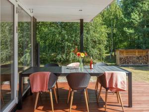 a dining table on a screened porch with chairs and a table at Holiday Home Selma - 300m from the sea in Bornholm in Vester Sømarken