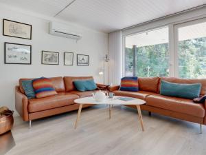 a living room with a couch and a table at Holiday Home Gottfrieda - 300m from the sea in Bornholm by Interhome in Vester Sømarken
