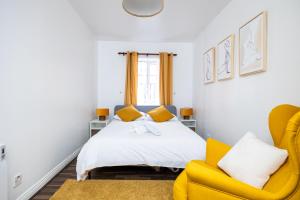 sypialnia z łóżkiem i żółtym krzesłem w obiekcie Delightful city centre apartment with balcony w Dublinie