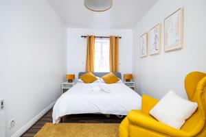 a bedroom with a bed and a yellow chair at Delightful city centre apartment with balcony in Dublin