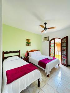 1 dormitorio con 2 camas y ventilador de techo en Pousada Alecrim Dourado, en Paraty