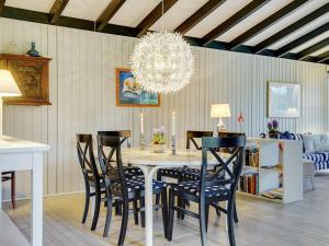 ein Esszimmer mit einem Tisch mit Stühlen und einem Kronleuchter in der Unterkunft Holiday Home Claudette - 1km from the sea in Sealand by Interhome in Hornbæk