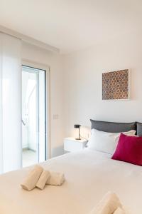 a white bedroom with a large bed with two towels at GENTILE 46 LUXURY ACCOMODATION in Bari