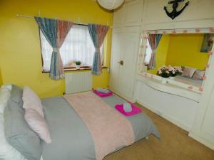 a bedroom with a large bed with a pink hat on it at SPACIOUS 3 BED HOUSE WITH PARKING & GOOD TRANSPORT in South Norwood