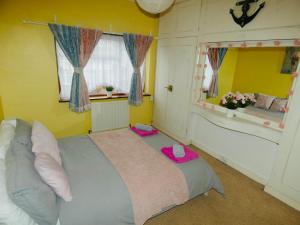 1 dormitorio con 1 cama grande con sombrero rosa en SPACIOUS 3 BED HOUSE WITH PARKING & GOOD TRANSPORT, en South Norwood
