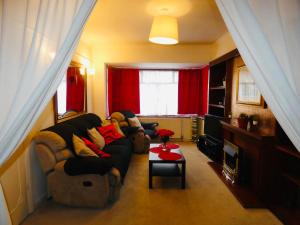 sala de estar con sofá y cortina roja en SPACIOUS 3 BED HOUSE WITH PARKING & GOOD TRANSPORT en South Norwood