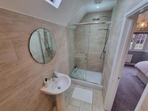 ein Badezimmer mit Dusche, Waschbecken und Spiegel in der Unterkunft 6 Bedroom Huge Holiday Home with parking in Luton + 19 Fotos