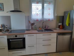 a kitchen with white cabinets and a sink and windows at CENT UN... 