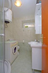 ein Badezimmer mit einer Waschmaschine und einem Waschbecken in der Unterkunft House Marija in Lastovo