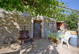 eine Terrasse mit einem Tisch und Stühlen neben einem Gebäude in der Unterkunft House Marija in Lastovo