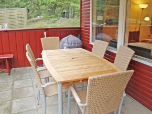 a wooden table and chairs on a patio at Holiday Home Jerk - 300m from the sea in Bornholm in Vester Sømarken