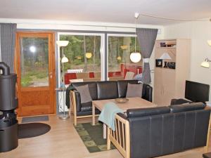 a living room with a couch and a table at Holiday Home Apelone - 300m from the sea in Bornholm by Interhome in Vester Sømarken