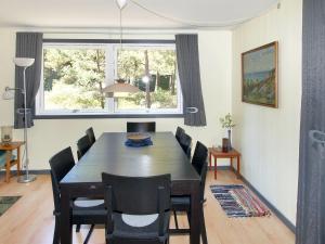 a dining room with a table and chairs and a window at Holiday Home Apelone - 300m from the sea in Bornholm by Interhome in Vester Sømarken