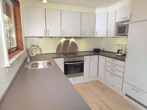 a kitchen with white cabinets and a sink at Holiday Home Apelone - 300m from the sea in Bornholm by Interhome in Vester Sømarken