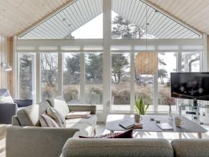 un soggiorno con mobili bianchi e una grande finestra di Holiday Home Ansgar - 150m from the sea by Interhome a Vester Sømarken