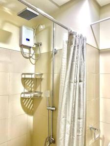 uma casa de banho com uma cortina de chuveiro em MoA S Residences Family Suite with balcony em Manila