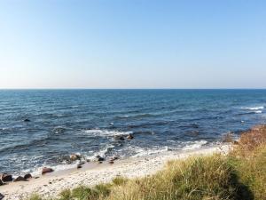 a beach with rocks in the ocean on a sunny day at Holiday Home Sina - 950m from the sea in Bornholm in Vester Sømarken