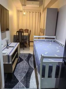 um quarto com uma cama e uma sala de jantar com uma mesa em MoA S Residences Family Suite with balcony em Manila