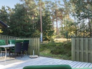 a patio with a table and chairs on a wooden deck at Holiday Home Sina - 950m from the sea in Bornholm in Vester Sømarken