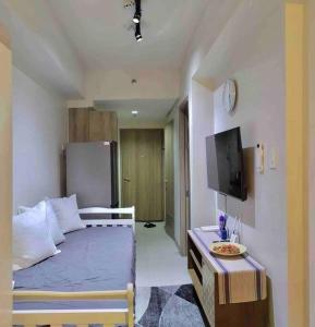 um quarto com uma cama e uma televisão num quarto em MoA S Residences Family Suite with balcony em Manila