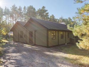 a small house with a garage in the woods at Holiday Home Sina - 950m from the sea in Bornholm in Vester Sømarken