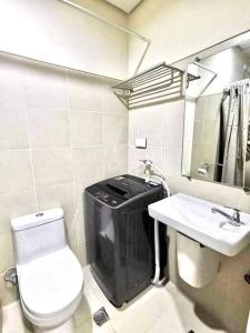 uma pequena casa de banho com WC e lavatório em MoA S Residences Family Suite with balcony em Manila