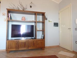 a living room with a television on a wooden entertainment center at Casa Margherita in Nebida