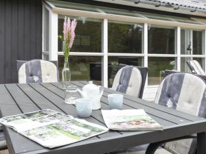 a gray table with a vase of flowers on it at Holiday Home Henrich - 300m from the sea in Bornholm in Vester Sømarken