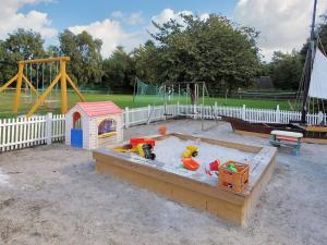 a sandbox in a park with a play set and a playground at Apartment Annamia - 250m from the sea by Interhome in Neksø