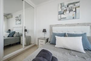 een slaapkamer met een grote spiegel en een bed bij Mirador De Mijas Luxury Apt Blq 6 Mijas in Mijas