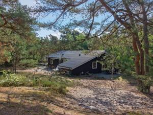 a black house in the middle of a forest at Holiday Home Heilo - 500m from the sea in Bornholm in Vester Sømarken
