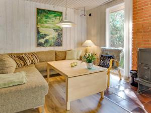 a living room with a couch and a table at Holiday Home Hildegerd - 500m from the sea in Bornholm by Interhome in Vester Sømarken