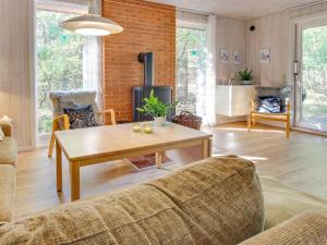 a living room with a table and a fireplace at Holiday Home Hildegerd - 500m from the sea in Bornholm by Interhome in Vester Sømarken